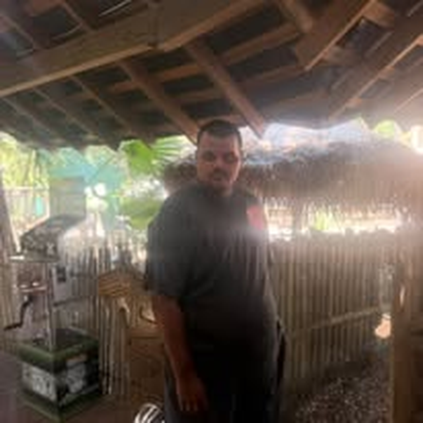 A staff member standing inside a tiki-style pavilion during an outing.