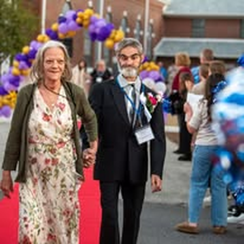 A couple walking arm in arm at the community gala.