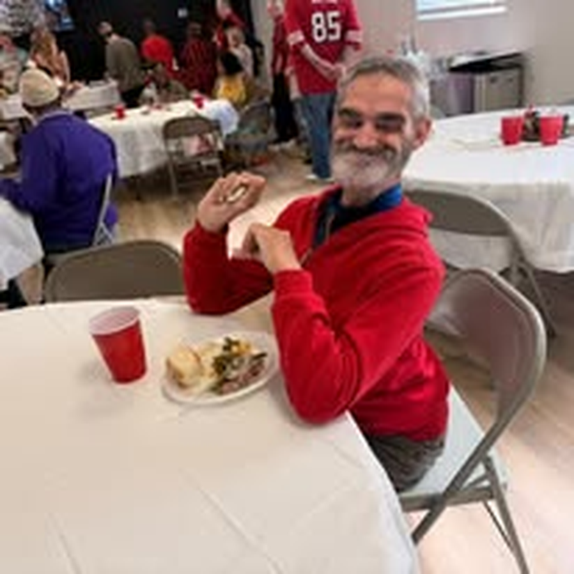 A volunteer digging in to a meal at the holiday party.