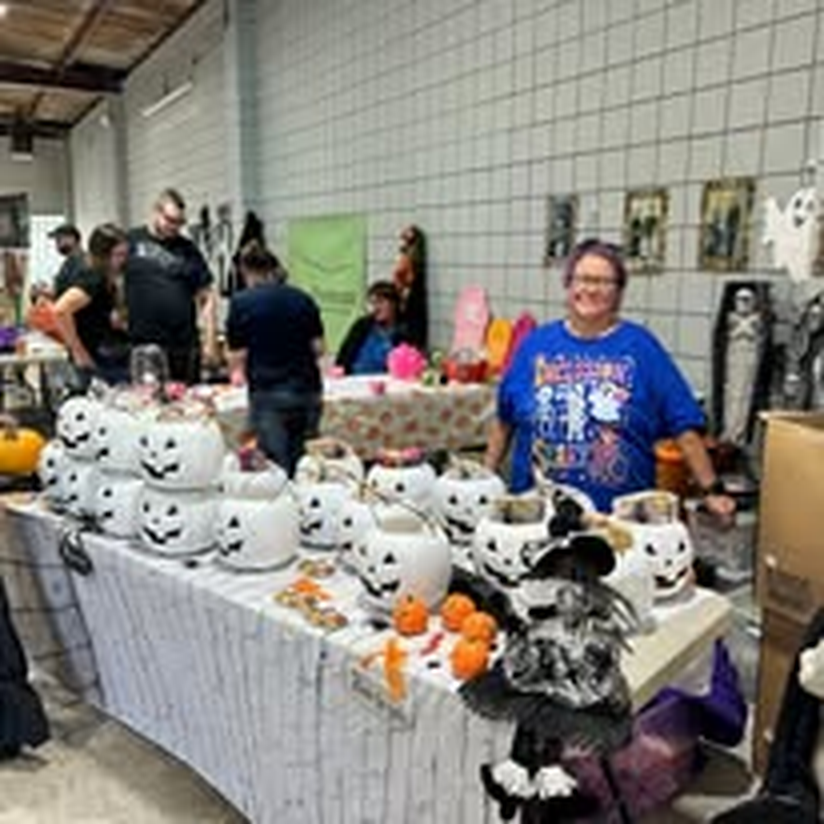A volunteer with painted ceramic pumpkins at the Halloween craft market.