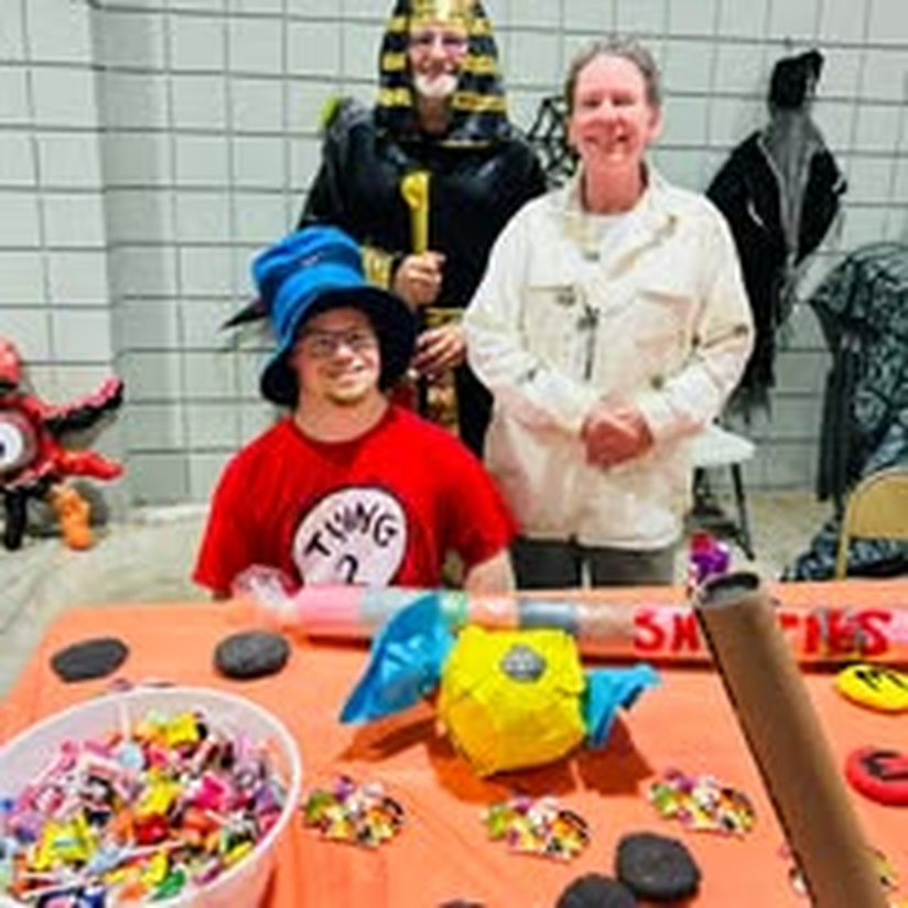 A child in costume collecting candy at the Halloween market.